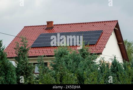 Hausdach mit Photovoltaikmodulen. Historisches Bauernhaus mit modernen Sonnenkollektoren auf Dach und Wand Hochwertiges Foto Stockfoto