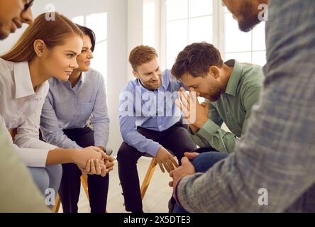 Ein Team von Freunden, Kollegen oder Mitgliedern der Gruppentherapie tröstet und unterstützt traurige Menschen Stockfoto