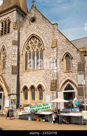 Ein Pflanzenverkauf außerhalb der United Reform Church in The Strand, Dawlish, Devon, England, Großbritannien. Passanten und Damen, die Waren verkaufen. Stockfoto