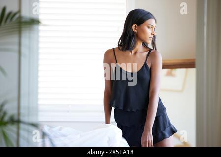 Denken, Morgen und Frau im Apartment mit Schlafanzug für Outfit-Ideen, erinnern Sie sich und entspannen Sie sich für die Ruhe zu Hause. Indisches Gen z Girl, Wochenende und Tagtraum Stockfoto