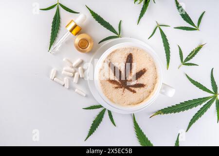 Medizinisches Cannabis Hanf Kaffee Latte. Tasse cremiger geschlagener Kaffee mit Cannabisöltropfen und gezeichnetem Blatt, mit Hanfblättern auf weißem Hintergrund Stockfoto