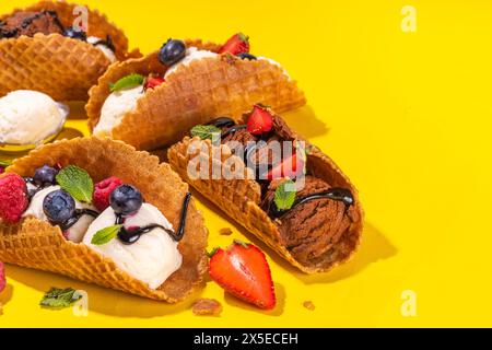 Verschiedene süße Taco-Eiscreme. Waffel-Taco-Muscheln mit Schokolade- und Vanillegeschmack, Eiscreme mit verschiedenen Früchten, Beeren und Garnierungen Stockfoto