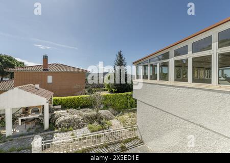 Hinterfassade der Villa mit Grundstück mit Granitsteinböden und einem großen Pavillon mit Fenstern Stockfoto