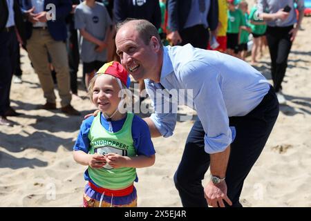 Der Prinz von Wales, bekannt als Duke of Cornwall, posiert für ein Foto mit einem Mitglied des Holywell Bay Surf Life Saving Club während eines Besuchs am Fistrall Beach in Newquay. Treffen mit lokalen Organisationen, die sich für die Sicherheit im Meer und am Strand einsetzen. Bilddatum: Donnerstag, 9. Mai 2024. Stockfoto