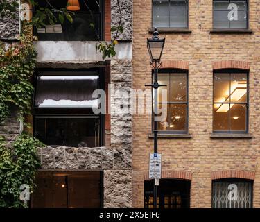 Kontextbezogener Blick auf quadratische Fenster und Kalksteinrahmen im Kontrast zum Gebäude nebenan. 15 Clerkenwell Close, London, Großbritannien. Architekt Stockfoto