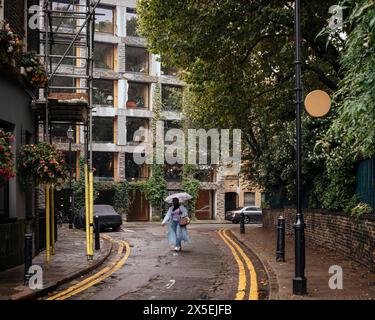 Ansicht der Rahmenverkleidung mit quadratischen Fenstern im Zusammenhang mit umliegenden Gebäuden und Bäumen. 15 Clerkenwell Close, London, Großbritannien. Architekt: A Stockfoto