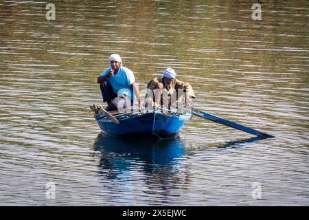 Lokale Ägypter fischen auf dem Nil in Ägypten. Es werden kleine Ruderboote verwendet, aus denen Netze gegossen und dann wieder verstaut werden. Stockfoto