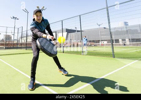 Mann spielt Paddeltennis auf dem Hallenplatz Stockfoto