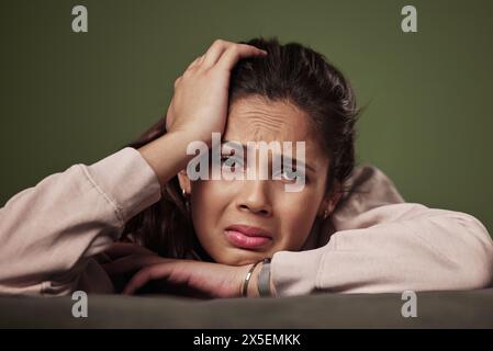 Frau, Stress und Weinen auf der Couch für psychische Gesundheit mit Angst, Kopfschmerzen und Depression mit Arbeitslosigkeit Krise. Schmerzen, frustrierte und müde Gen z Stockfoto