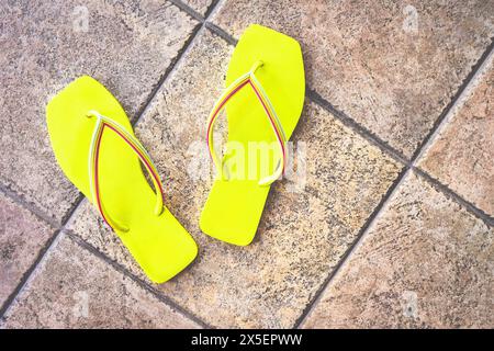 Gelbe Hausschuhe auf beigefarbenem Hintergrund. Stockfoto