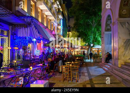 Beleuchtete Straßencafés und Geschäfte bei Nacht im lebhaften Viertel Monastiraki in der Nähe des Syntagma-Platzes in Athen, Griechenland. Stockfoto