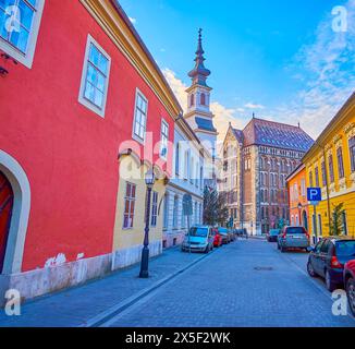 Das rot-gelbe mittelalterliche jüdische Gebetshaus und das Nationalarchiv Ungarns im Hintergrund, Blick von der Tancsics Mihaly Street, Budapest, Ungarn Stockfoto