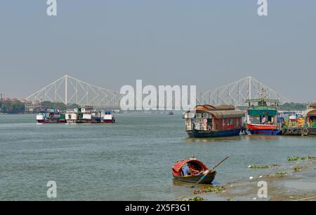 Geschäftige Wasserstraße des Hoodly River mit Howrah Bridge im Hintergrund Stockfoto