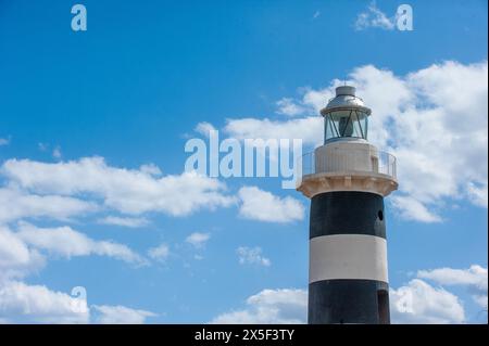 Schwarz-weiß-Leuchtturm in Cala Mosca, Cagliari, Sardinien, unter einem blauen Himmel Stockfoto