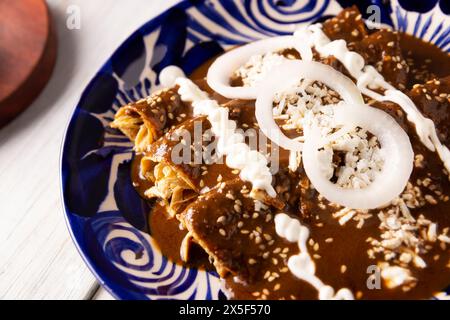 Hühnerenmoladas. Auch bekannt als Mole poblano enchiladas, sind sie ein typisches mexikanisches Gericht, das in Mexiko und dem Rest der Welt sehr beliebt ist. Stockfoto