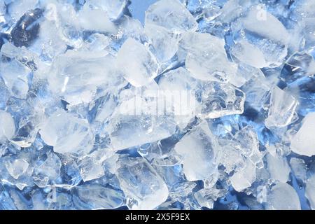 Stücke zerstoßenes Eis auf hellblauem Hintergrund, über der Ansicht Stockfoto