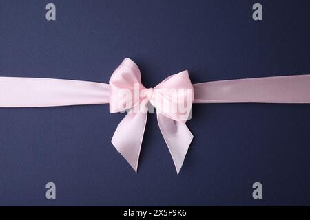 Pinkes Satinband mit Schleife auf blauem Hintergrund, Draufsicht Stockfoto