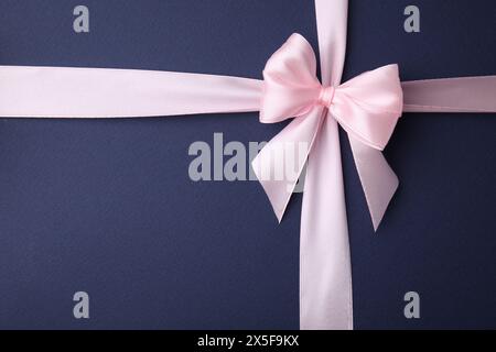 Pinkes Satinband mit Schleife auf blauem Hintergrund, Draufsicht Stockfoto