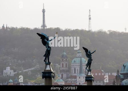 prag, tschechische republik - 3. März 2024: Engelstatuen auf Brücke mit historischem Gebäudehintergrund Stockfoto