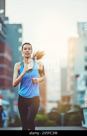 Frau, Straße und Laufen zum Training mit Ohrhörern, Musik-Streaming-App und Telefon am Morgen. Mädchen, Person oder Läufer mit Audio-, Radio- oder Hörfunktion Stockfoto