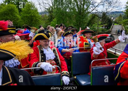 Die Stadtschreier lächeln (Pagen und Pagen in bunten Flechtuniformen) sitzen auf dem offenen Busdeck - Ilkley, West Yorkshire, England, Großbritannien. Stockfoto