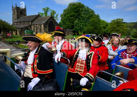 Die Stadtschreier lächeln (Pagen und Pagen in bunten Flechtuniformen) sitzen auf dem offenen Busdeck - Ilkley, West Yorkshire, England, Großbritannien. Stockfoto