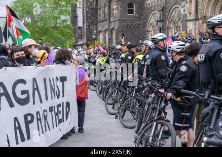 Die Polizei richtete eine menschliche Barrikade mit pro-palästinensischen und pro-israelischen Demonstranten vor dem Studentenlager ein, das den King's College Circle in der U besetzt Stockfoto