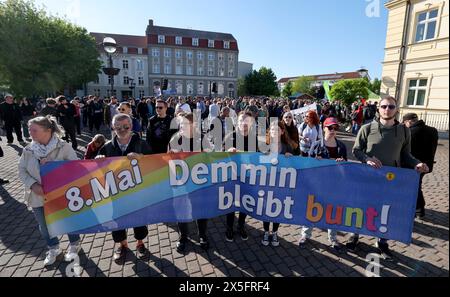 Demmin, Deutschland. Mai 2024. Die Teilnehmer versammeln sich auf dem Marktplatz zu einer Demonstration gegen einen marsch von Rechtsextremisten, auf einem Banner steht: „8. Mai Demmin bleibt bunt!“. Die "Aktionsallianz vom 8. Mai" hat ein Friedensfest und eine Gegendemonstration gefordert. Grund für den rechtsextremen marsch am Abend ist ein Massenselbstmord in der Stadt während der Invasion der Roten Armee Ende April/Anfang Mai 1945. Quelle: Bernd Wüstneck/dpa/Alamy Live News Stockfoto