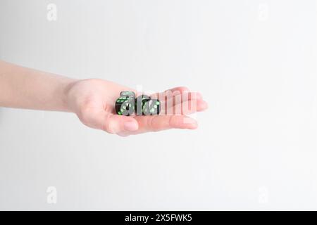 Frau, die Spielwürfel in der Hand auf weißem Hintergrund hält, Nahaufnahme Stockfoto