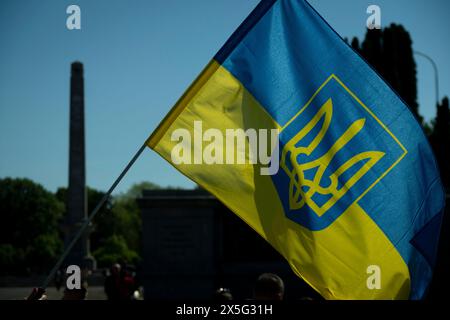 Warschau, Polen. Mai 2024. Am 9. Mai 2024 wird auf dem sowjetischen Militärfriedhof in Warschau, Polen, mit ukrainischer Flagge gesehen. Die Demonstranten unterbrachen den Besuch des russischen Botschafters Sergej Andrejew mit lauten Schreien, während sie Kleider trugen, die die Namen bombardierter ukrainischer Städte trugen und mit Bühnenblut bedeckt waren. (Foto: Jaap Arriens/SIPA USA) Credit: SIPA USA/Alamy Live News Stockfoto