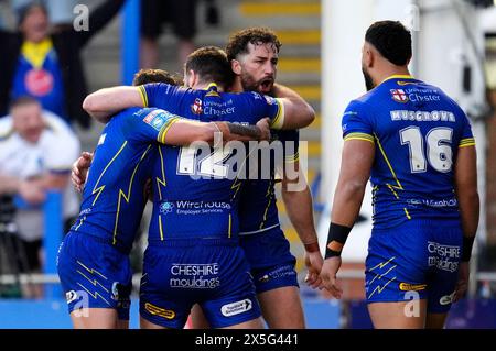 Warrington Wolves' Toby King (Mitte rechts) feiert mit seinen Teamkollegen, nachdem sie den dritten Versuch ihrer Mannschaft während des Spiels der Betfred Super League im Halliwell Jones Stadium in Warrington erzielt haben. Bilddatum: Donnerstag, 9. Mai 2024. Stockfoto