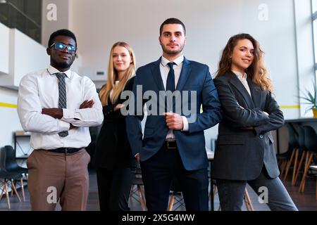 Selbstbewusstes multiethnisches Unternehmensteam in Bürokleidung steht zusammen und strahlt Führungsstärke und Zusammenarbeit in modernen Arbeitsbereichen aus. Afrikanisch, Kaukasisch, Asiatisch Stockfoto