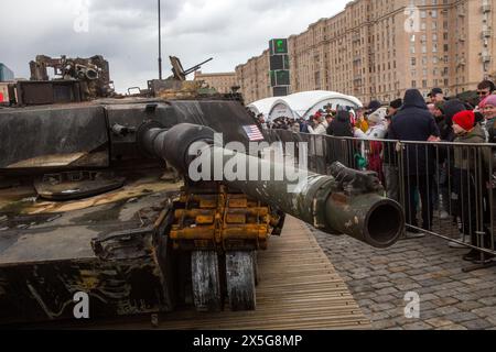 Moskau, Russland. Mai 2024. Besucher sehen und machen Fotos von einem in den USA hergestellten Abrams-Panzer M1A1, der im Vordergrund von russischen Truppen während der Sonderoperation in der Ukraine getroffen und gefangen genommen wurde, die in Moskau, Russland, ausgestellt ist. In der russischen Hauptstadt wurde eine Ausstellung mit militärischer Ausrüstung eröffnet, die während der Kämpfe in der Ukraine von Kiew eingenommen wurde. Stockfoto