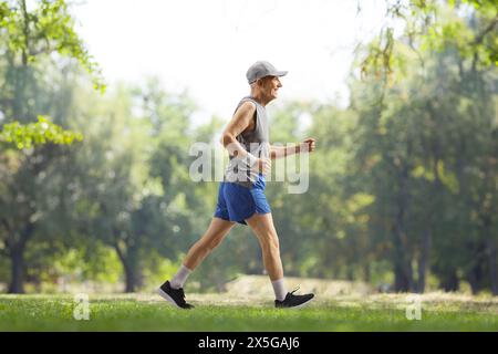 Profilaufnahme eines älteren Mannes in Sportbekleidung, der in einem Park spaziert Stockfoto