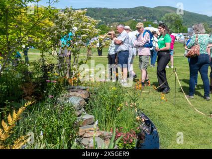 Mai 2024. Das RHS Malvern Spring Festival wurde heute an einem warmen sonnigen Tag eröffnet. Tausende von Besuchern besuchten die jährliche Blumenausstellung auf dem Three Counties Showground in Malvern, Worcestershire, England, Großbritannien. Die Veranstaltung findet über 4 Tage statt und endet am 12. Mai 2024. Im Bild: Leute, die den Macmillan Legacy Garden bewundern, entworfen von Kerianne Fitzpatrick & TJ Kennedy, einer der Schaugärten. Stockfoto