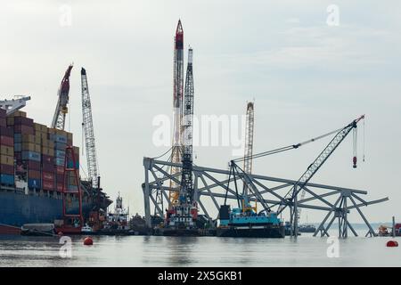 Dundalk, Vereinigte Staaten von Amerika. Mai 2024. Bergungsmannschaften verwenden eine hydraulische Bergungsklaue, um das Wrack der eingestürzten Francis Scott Key Bridge über den Patapsco River am 8. Mai 2024 in der Nähe von Dundalk, Maryland, zu beseitigen. Die Brücke wurde am 26. März von dem 984-Fuß-Containerschiff MV Dali getroffen und stürzte zusammen, wobei sechs Arbeiter ums Leben kamen. Quelle: Christopher Rosario/U. S Army Corps of Engineers/Alamy Live News Stockfoto