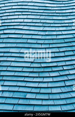 Die blauen Schindeln auf dem Dach sind verwittert und abgenutzt. Das Dach ist aus Holz und hat eine blaue Farbe Stockfoto
