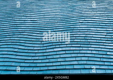 Die blauen Schindeln auf dem Dach sind verwittert und abgenutzt. Das Dach ist aus Holz und hat eine blaue Farbe Stockfoto