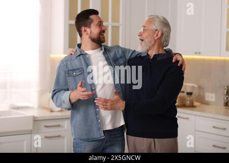 Glücklicher Sohn und sein Vater reden zu Hause Stockfoto