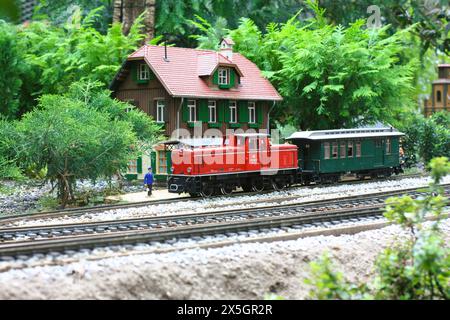 Ein Modelleisenzug mit einem Modellhaus im Hintergrund. Stockfoto