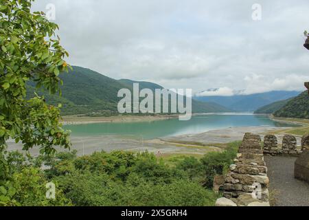 Malerischer Blick auf die Ananuri Festung Komplex mit türkisfarbenem Wasser des Zhinvali Reservoir umgeben von Bergen auf dem georgischen Militär Stockfoto