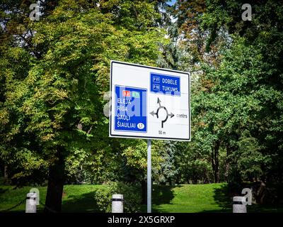 Bild eines typischen lettischen Verkehrsschildes, das den europäischen Normen entspricht und den Fahrern die Ortsanweisungen in lettland und den wichtigsten Städten in der Umgebung anzeigt. Stockfoto