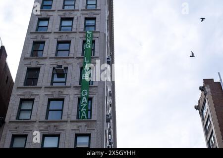 Ein Banner mit der Aufschrift „Long Live Gaza“ hängt an einem Fenster einer Parsons School of Design, gegenüber der New School. Heute fand eine propalästinensische Kundgebung vor der New School statt, um „das letzte verbliebene Lager in New York zu schützen“. Das Lager wurde Mittwochabend von der Fakultät der New School in der Lobby eines der akademischen Gebäude der Fifth Avenue eingerichtet. Der Protest endete mit mehreren Verhaftungen, darunter zwei Gegenprotestierende, die verhaftet wurden, weil sie mehrere Demonstranten mit Keule beschossen hatten. Stockfoto