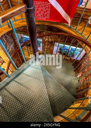 Blick von oben auf eine Wendeltreppe aus Metall mit freiliegenden Ziegelwänden und einer Tauchflagge in einer historischen St. Augustine Attraktion, Florida Stockfoto