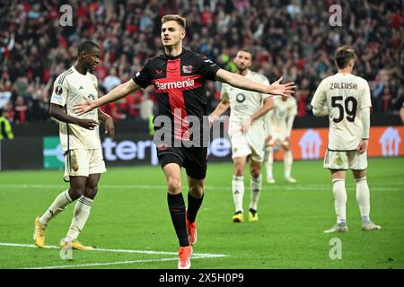 Leverkusen, Deutschland. Mai 2024. Josip Stanisic (vorne) von Bayer 04 Leverkusen feiert sein Tor beim Halbfinalspiel der UEFA Europa League zwischen Bayer 04 Leverkusen und Roma am 9. Mai 2024 in Leverkusen. Quelle: Ulrich Hufnagel/Xinhua/Alamy Live News Stockfoto