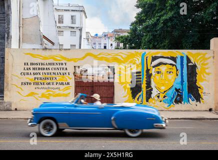 1950er Jahre Chevy Passes Havanna Wandgemälde. Der Text lautet: "Die Schikanen und Maßnahmen gegen Kuba sind unmenschlich und bestehen fort, das muss aufhören. Keine Blockade mehr Stockfoto