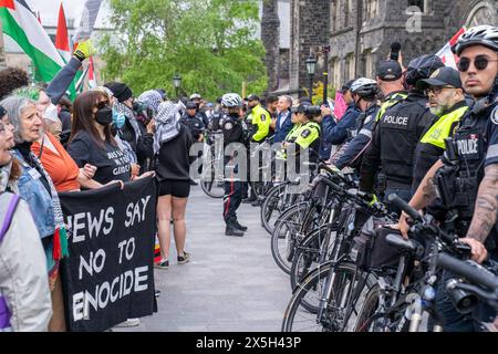 Die Polizei hat während der Demonstration eine menschliche Barrikade zwischen Pro-Israel und Pro-Palästinensern errichtet. Pro-palästinensische und pro-israelische Demonstranten an der University of Toronto außerhalb des Studentenlager im King College Circle. Studenten und Dozenten, die sich für die palästinensischen Rechte einsetzten, zeigten Banner, die die Not der Palästinenser darstellten, antizionistische und anti-israelische Botschaften, während pro-israelische Proteste Studenten und Unterstützer daran beteiligten, israelische Flaggen zu schwenken und Dialoge zu führen, um Israels Aktionen und Politik zu verteidigen. Stockfoto