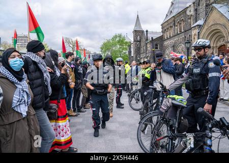 Die Polizei hat während der Demonstration eine menschliche Barrikade zwischen Pro-Israel und Pro-Palästinensern errichtet. Pro-palästinensische und pro-israelische Demonstranten an der University of Toronto außerhalb des Studentenlager im King College Circle. Studenten und Dozenten, die sich für die palästinensischen Rechte einsetzten, zeigten Banner, die die Not der Palästinenser darstellten, antizionistische und anti-israelische Botschaften, während pro-israelische Proteste Studenten und Unterstützer daran beteiligten, israelische Flaggen zu schwenken und Dialoge zu führen, um Israels Aktionen und Politik zu verteidigen. Stockfoto