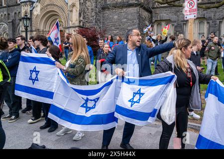 Toronto, Kanada. Mai 2024. Pro-israelische Anhänger halten während der Kundgebung mehrere israelische Flaggen. Pro-palästinensische und pro-israelische Demonstranten an der University of Toronto außerhalb des Studentenlager im King College Circle. Studenten und Dozenten, die sich für die palästinensischen Rechte einsetzten, zeigten Banner, die die Not der Palästinenser darstellten, antizionistische und anti-israelische Botschaften, während pro-israelische Proteste Studenten und Unterstützer daran beteiligten, israelische Flaggen zu schwenken und Dialoge zu führen, um Israels Aktionen und Politik zu verteidigen. Quelle: SOPA Images Limited/Alamy Live News Stockfoto