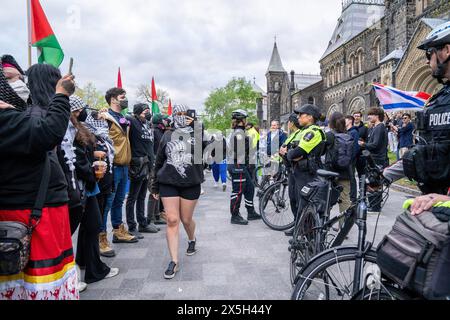 Die Polizei hat während der Demonstration eine menschliche Barrikade zwischen Pro-Israel und Pro-Palästinensern errichtet. Pro-palästinensische und pro-israelische Demonstranten an der University of Toronto außerhalb des Studentenlager im King College Circle. Studenten und Dozenten, die sich für die palästinensischen Rechte einsetzten, zeigten Banner, die die Not der Palästinenser darstellten, antizionistische und anti-israelische Botschaften, während pro-israelische Proteste Studenten und Unterstützer daran beteiligten, israelische Flaggen zu schwenken und Dialoge zu führen, um Israels Aktionen und Politik zu verteidigen. Stockfoto